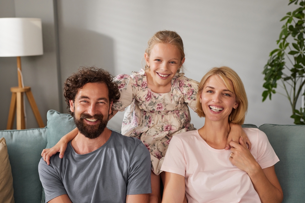 Smiling family sitting together at home