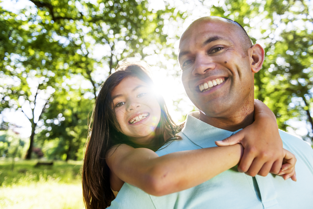 Smiling child with her father outdoors